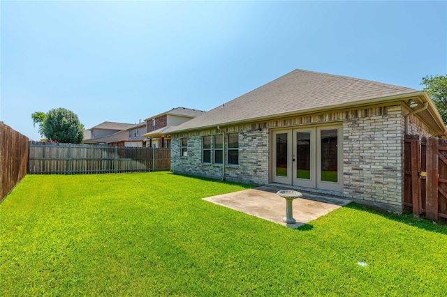 rear view of house with a lawn, a patio area, and french doors