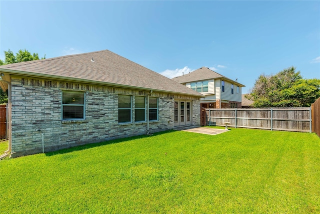 rear view of property featuring a yard and french doors