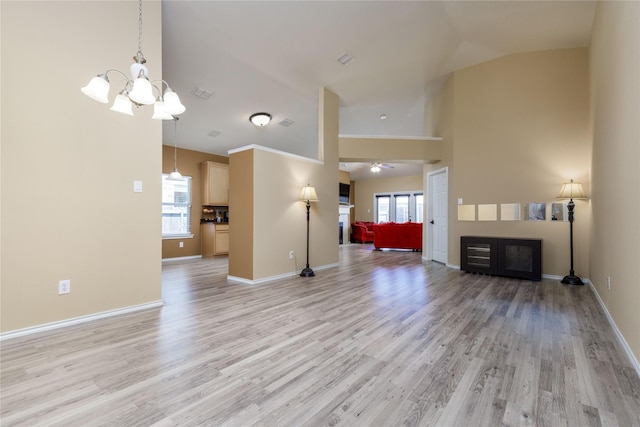 unfurnished living room with lofted ceiling, light wood-type flooring, and ceiling fan with notable chandelier