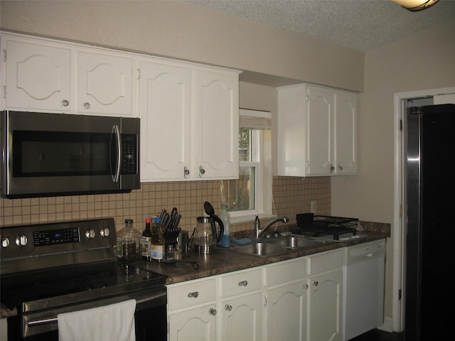 kitchen featuring white cabinets, sink, decorative backsplash, a textured ceiling, and stainless steel appliances