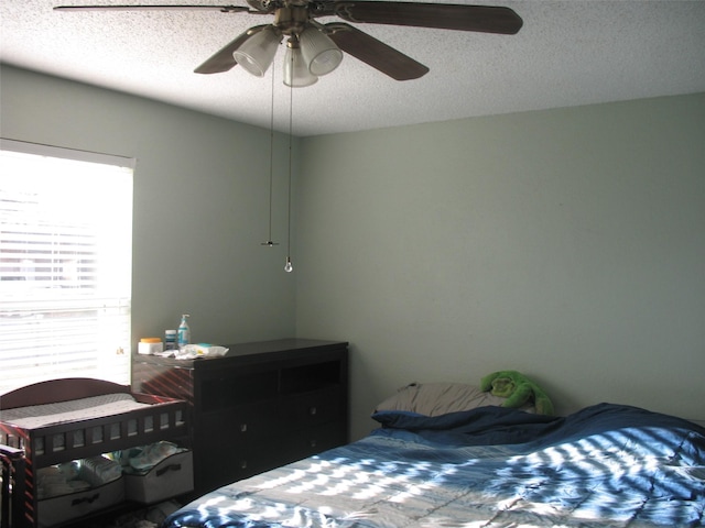 bedroom featuring ceiling fan and a textured ceiling