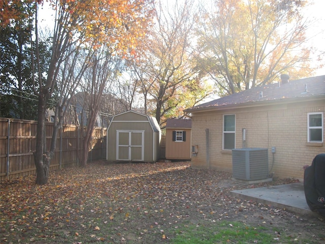 view of yard featuring a patio, central AC unit, and a storage shed