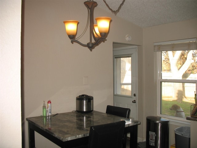 dining area with a textured ceiling and a notable chandelier