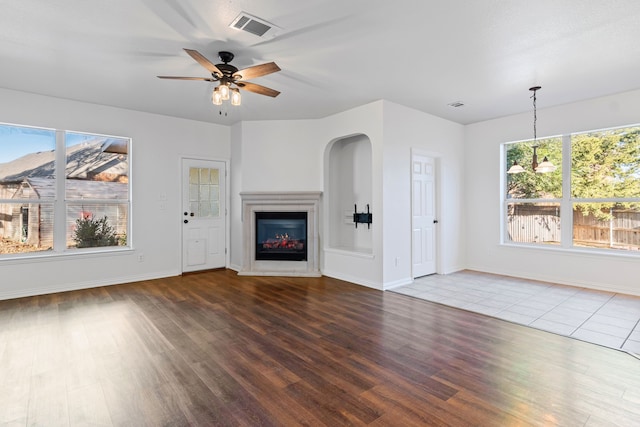 unfurnished living room with ceiling fan and wood-type flooring