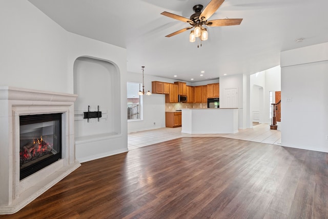 unfurnished living room featuring ceiling fan and light hardwood / wood-style floors