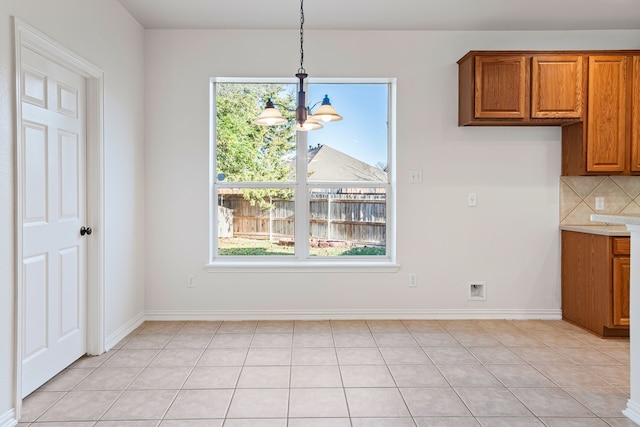 unfurnished dining area with light tile patterned flooring and a chandelier