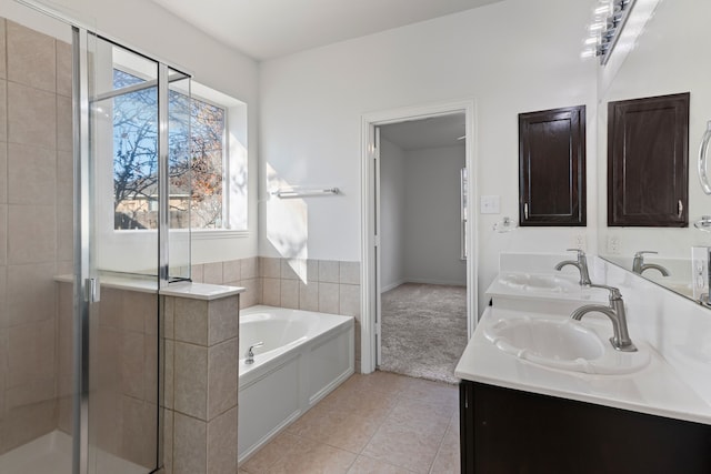 bathroom with tile patterned flooring, vanity, and shower with separate bathtub