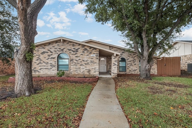 single story home with central AC unit and a front yard