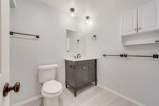 bathroom featuring hardwood / wood-style floors, vanity, and toilet