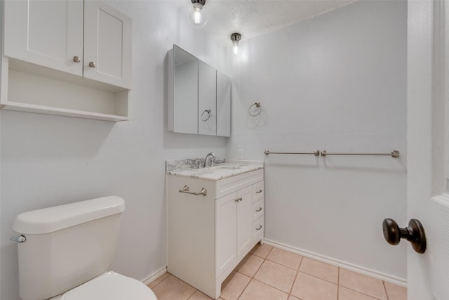 bathroom featuring tile patterned floors, vanity, a textured ceiling, and toilet