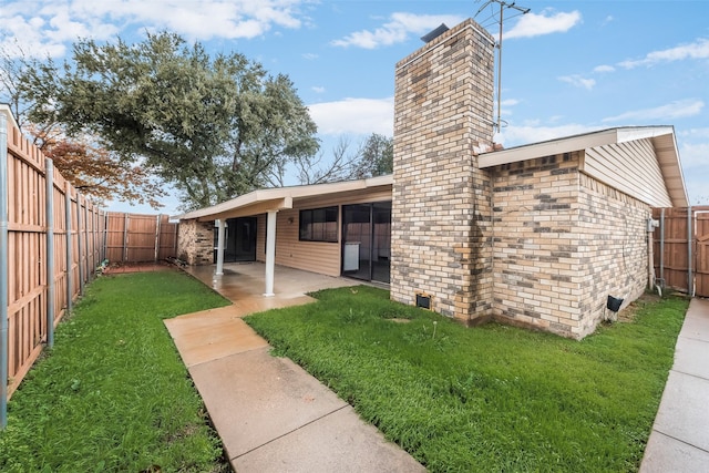 back of property with a lawn and a patio