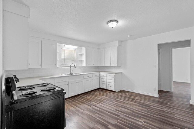 kitchen featuring white cabinets, a textured ceiling, dark wood-type flooring, and sink