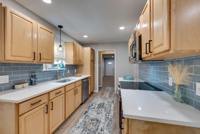 kitchen with light brown cabinetry, sink, light hardwood / wood-style floors, and appliances with stainless steel finishes