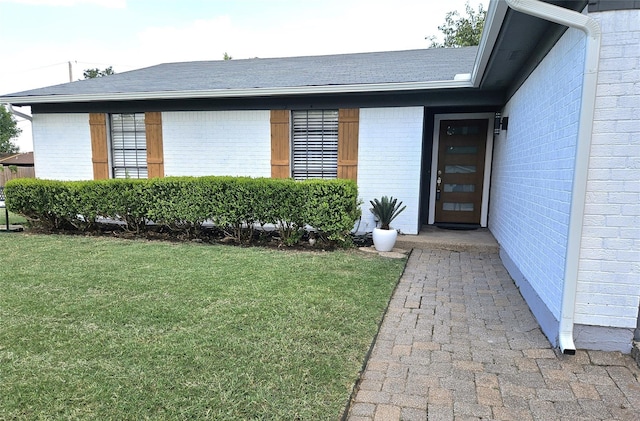 doorway to property with a lawn