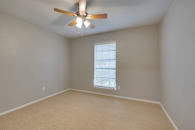 carpeted spare room featuring ceiling fan