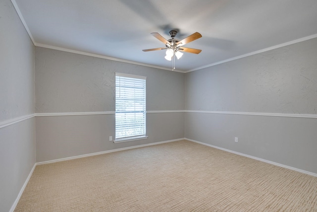 carpeted empty room featuring ceiling fan and crown molding