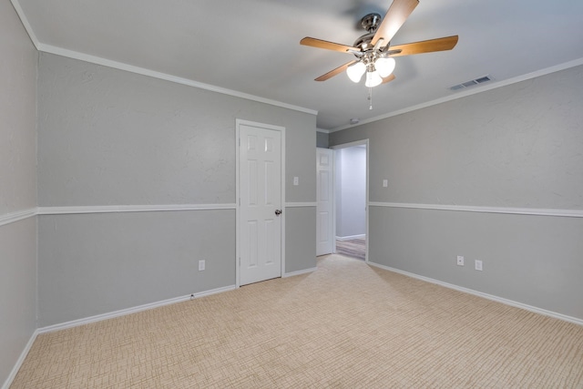 empty room featuring ceiling fan and ornamental molding