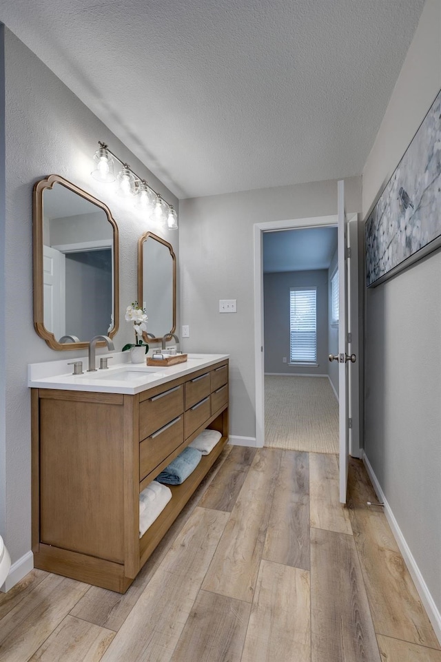 bathroom with vanity, wood-type flooring, and a textured ceiling