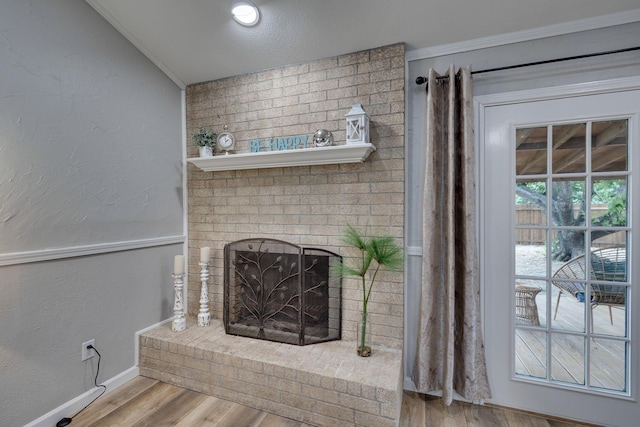 details featuring hardwood / wood-style floors, a brick fireplace, and crown molding