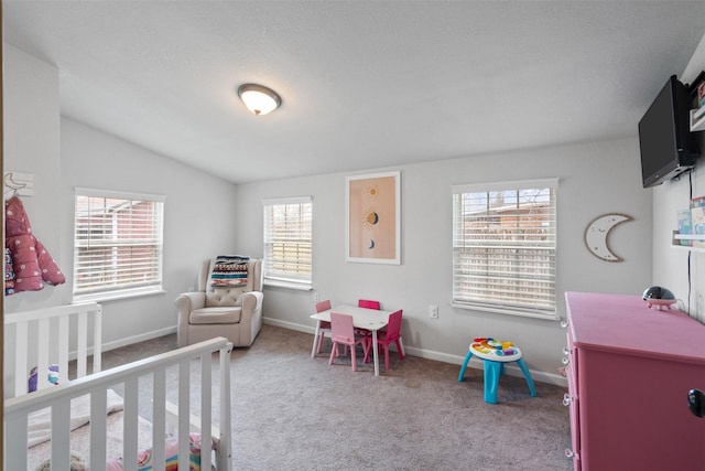 bedroom featuring a crib, vaulted ceiling, and carpet flooring