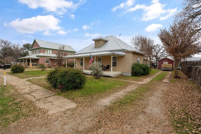 view of front of property featuring a garage, covered porch, and a front yard