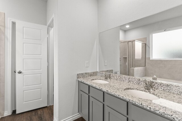 bathroom with hardwood / wood-style flooring, vanity, and shower with separate bathtub