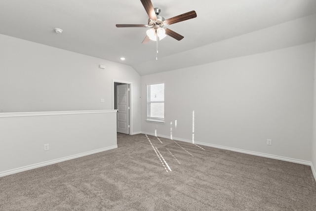 empty room with ceiling fan, carpet floors, and vaulted ceiling