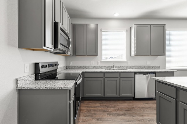 kitchen with appliances with stainless steel finishes, a healthy amount of sunlight, and gray cabinetry