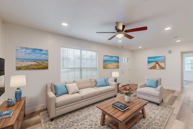 living room featuring light wood-type flooring and ceiling fan