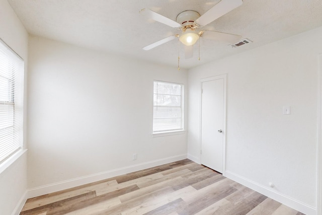 empty room with ceiling fan and light hardwood / wood-style flooring