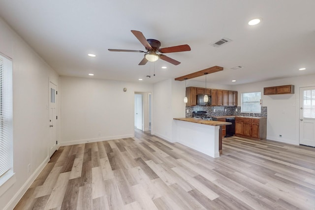 kitchen with ceiling fan, kitchen peninsula, light hardwood / wood-style floors, decorative light fixtures, and black appliances