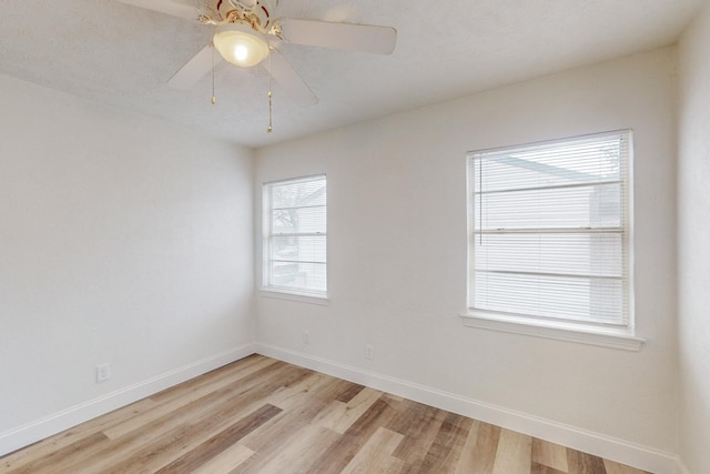 empty room with light hardwood / wood-style flooring, a wealth of natural light, and ceiling fan