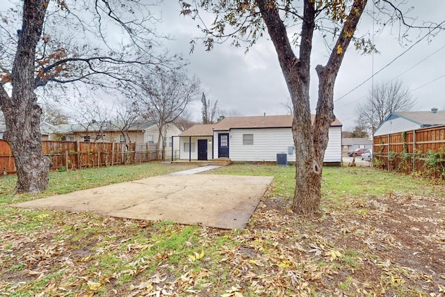 back of property with a yard and a patio