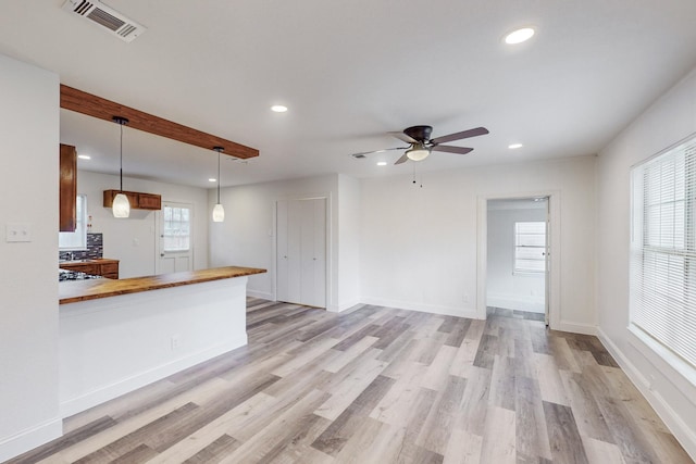 kitchen featuring butcher block countertops, ceiling fan, pendant lighting, and light hardwood / wood-style floors