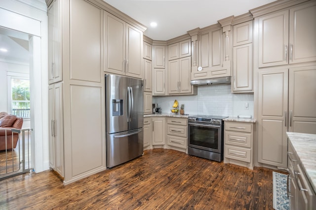 kitchen featuring appliances with stainless steel finishes, dark hardwood / wood-style flooring, light stone countertops, and decorative backsplash