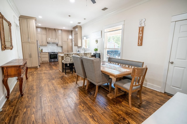 dining area featuring dark wood-type flooring, ceiling fan, and ornamental molding