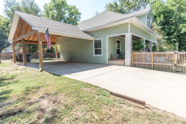 rear view of house featuring a yard and a carport