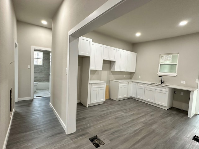 kitchen with recessed lighting, dark wood-type flooring, white cabinetry, a sink, and baseboards