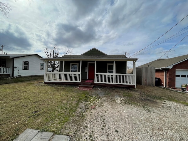 view of front of home featuring a garage, a front lawn, and covered porch