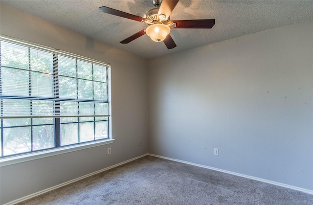 spare room with a textured ceiling, carpet floors, and ceiling fan