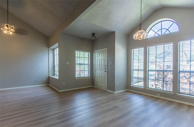 entryway with a healthy amount of sunlight, ceiling fan with notable chandelier, and hardwood / wood-style flooring