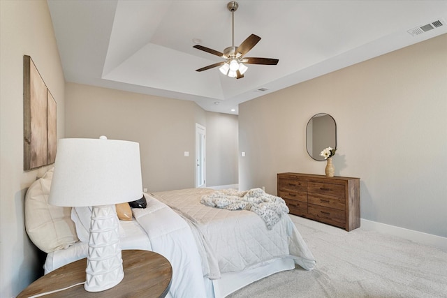 bedroom featuring carpet flooring, ceiling fan, and a tray ceiling