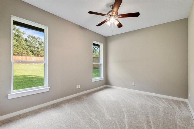 unfurnished room with ceiling fan, carpet floors, and a wealth of natural light