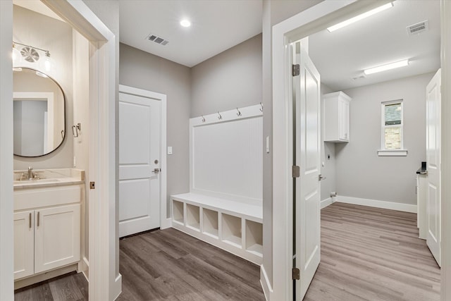 mudroom with light hardwood / wood-style floors and sink