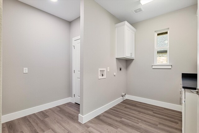 washroom featuring hookup for an electric dryer, hookup for a washing machine, cabinets, gas dryer hookup, and light hardwood / wood-style floors