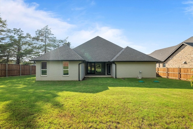 rear view of property featuring a lawn