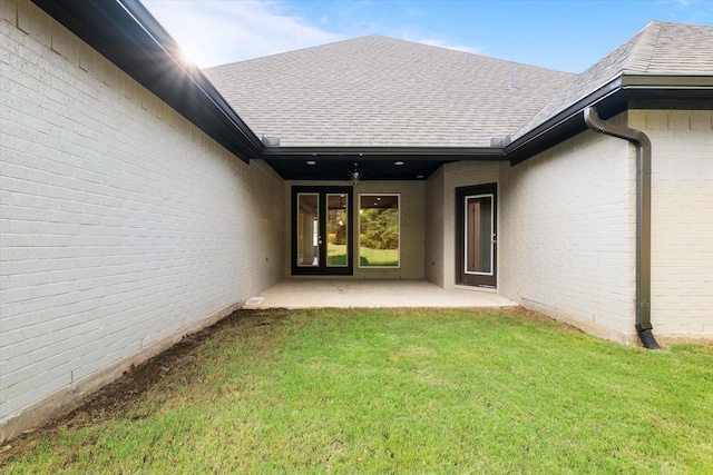 entrance to property with a yard and a patio area