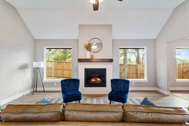 living room featuring hardwood / wood-style floors, high vaulted ceiling, and ceiling fan