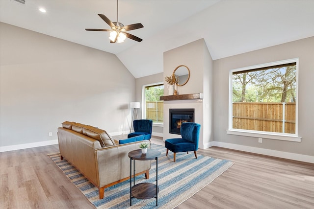 living room featuring light hardwood / wood-style floors, a wealth of natural light, lofted ceiling, and ceiling fan