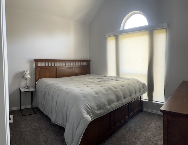 bedroom with dark carpet and lofted ceiling